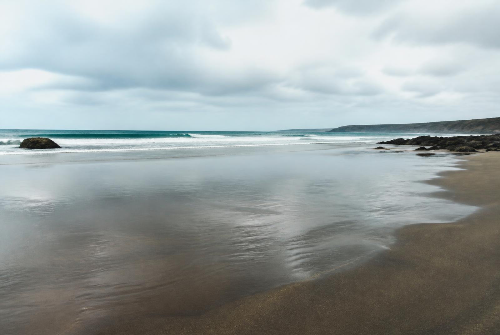 Praia na maré baixa com reflexos na areia molhada